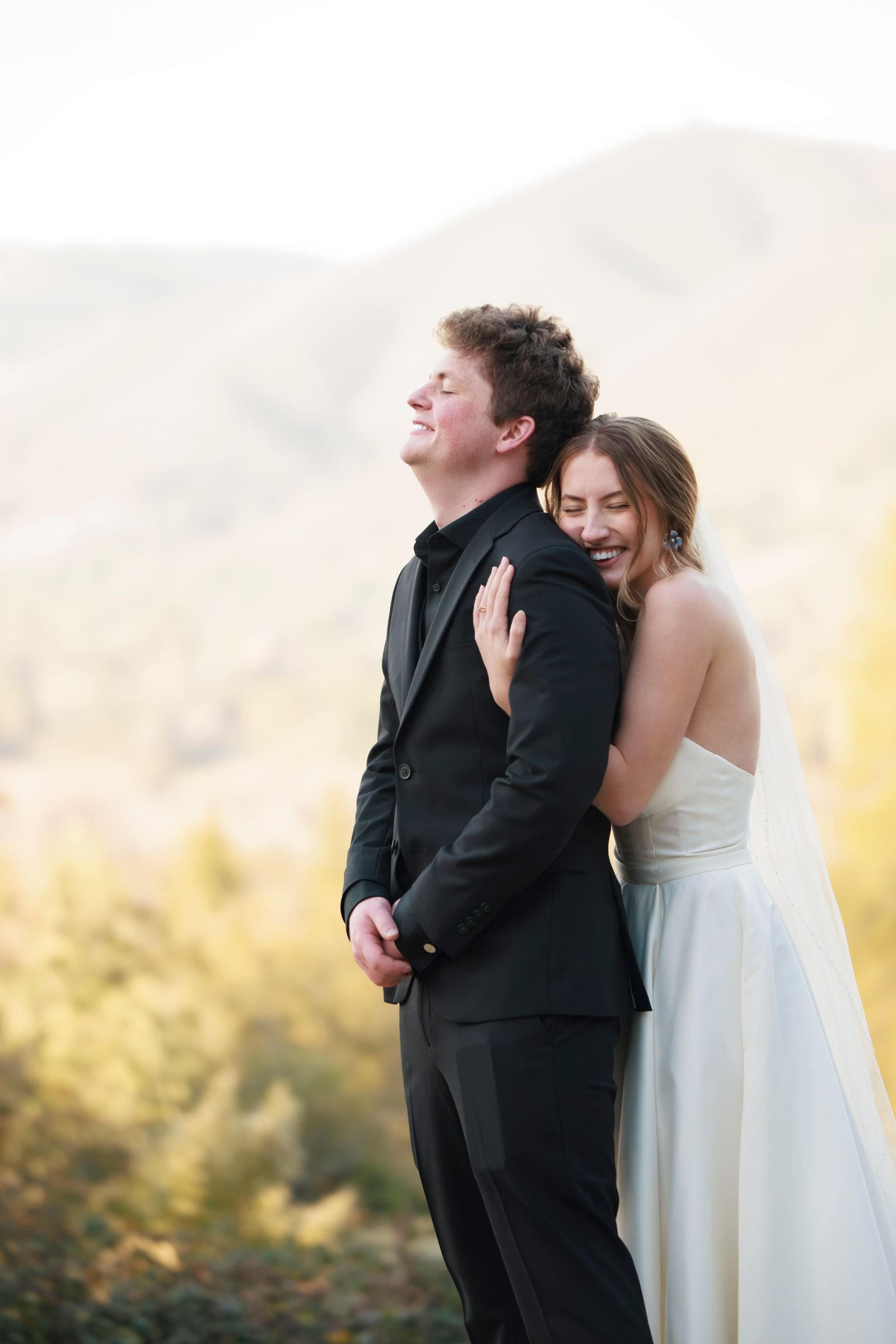 Joyful wedding couple embracing in a scenic landscape